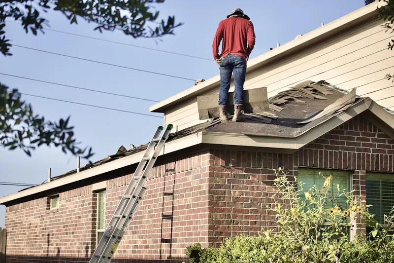 Professional roofer working on a residential roof in Sterling Woods